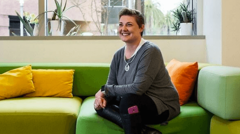 A person sitting on a couch, smiling