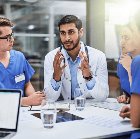 equipe médica reunida em torno de uma mesa