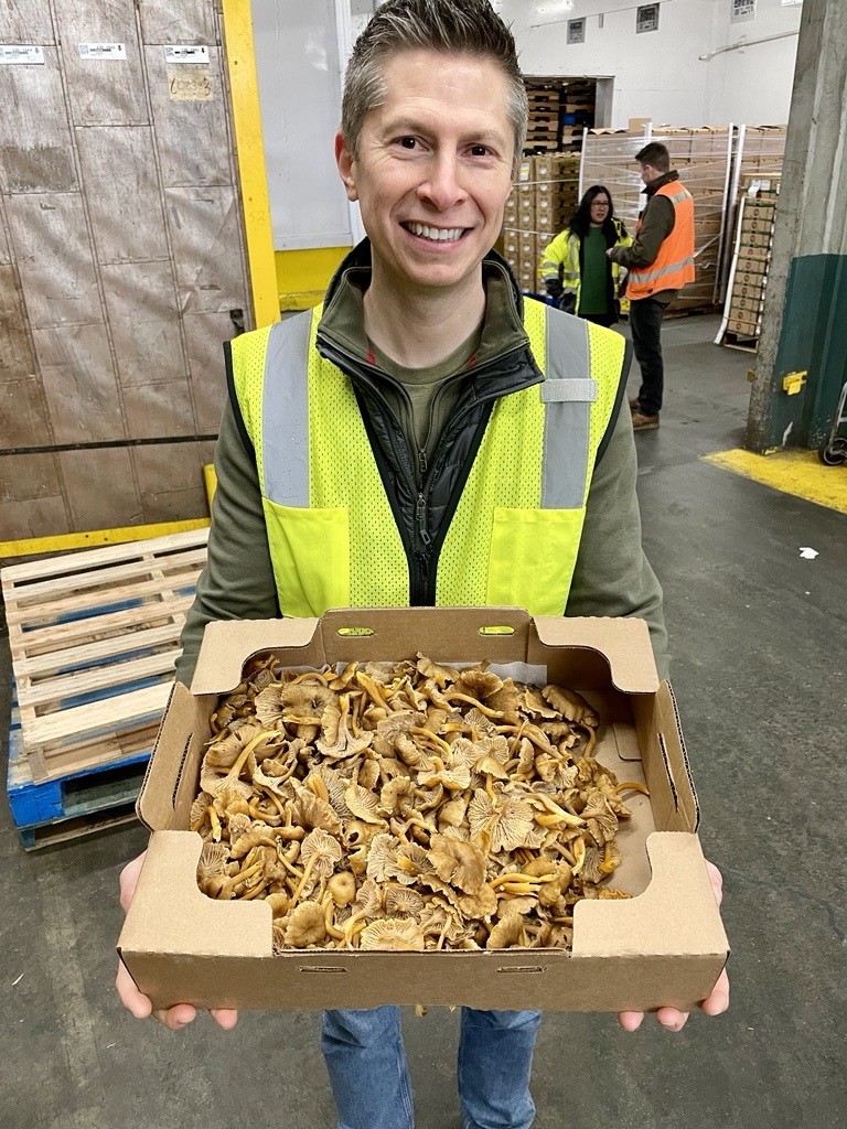 Darrick Bartley holding a box of mushrooms